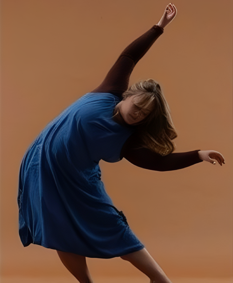 Dancer in blue dress against orange background.
